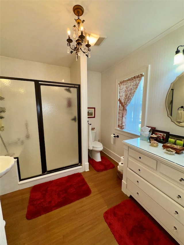 500 S Ross Ave, Mexia, TX 76667 - bathroom featuring wood finished floors, a shower stall, ornamental molding, toilet, and a chandelier