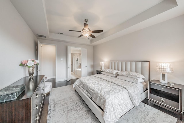 3723 Birch Wood Ct, Northlake, TX 76226 - bedroom with a tray ceiling, wood finished floors, baseboards, ensuite bath, and a ceiling fan