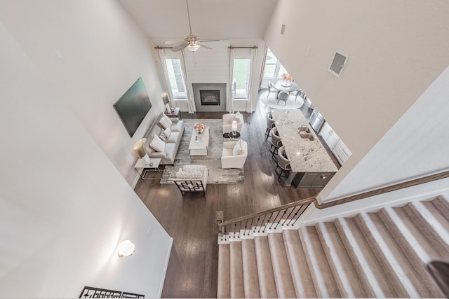 3723 Birch Wood Ct, Northlake, TX 76226 - living area with wood finished floors, a high ceiling, a ceiling fan, a glass covered fireplace, and stairway