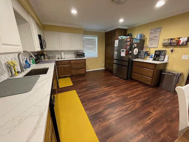 4054 Lakeshore Dr, Lone Star, TX 75668 - kitchen featuring appliances with stainless steel finishes, backsplash, dark wood finished floors, light stone counters, and recessed lighting