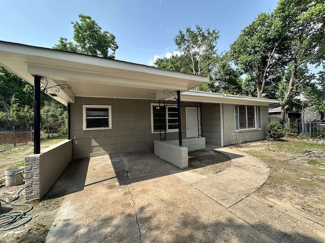 view of front of house with fence and an attached carport