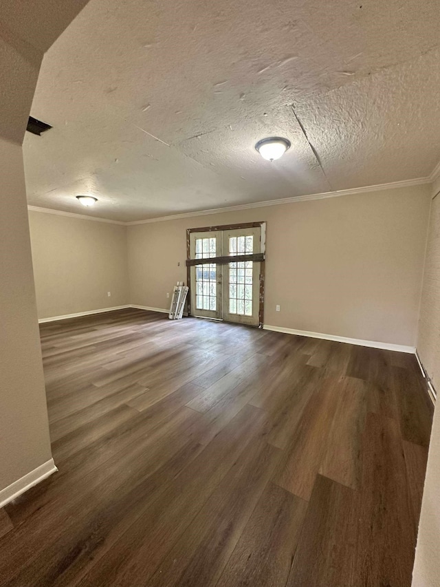 empty room featuring wood finished floors, crown molding, a textured ceiling, baseboards, and french doors