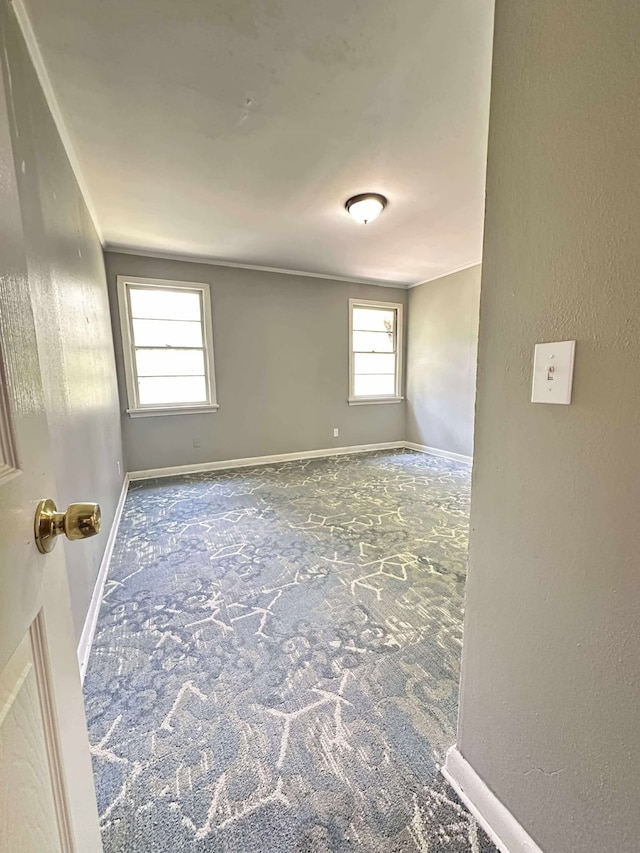 carpeted empty room featuring baseboards