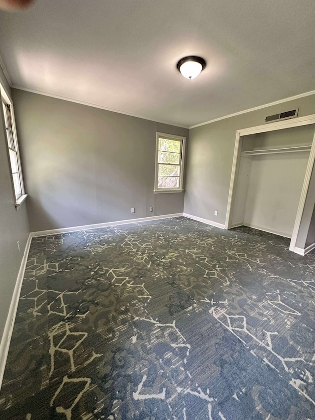 unfurnished bedroom featuring baseboards, carpet floors, and crown molding