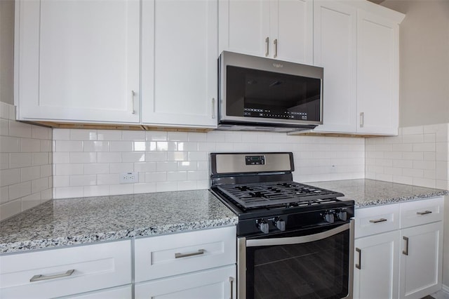 1683 Timpson Dr, Forney, TX 75126 - kitchen with appliances with stainless steel finishes, white cabinets, light stone counters, and decorative backsplash
