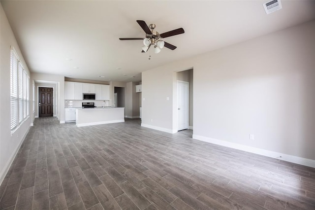 1683 Timpson Dr, Forney, TX 75126 - unfurnished living room featuring baseboards, a ceiling fan, dark wood-type flooring, and a sink