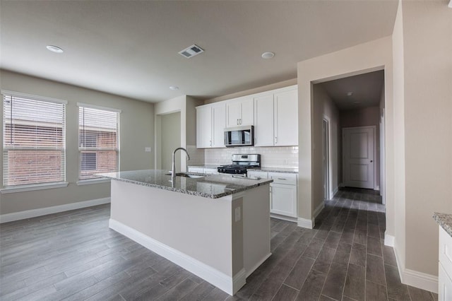 1683 Timpson Dr, Forney, TX 75126 - kitchen featuring stainless steel appliances, a sink, dark wood-style flooring, light stone counters, and white cabinets