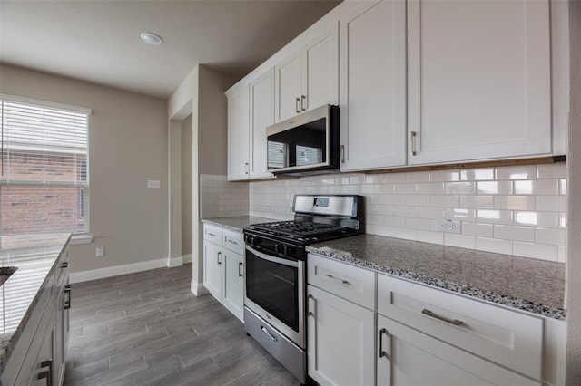 1683 Timpson Dr, Forney, TX 75126 - kitchen featuring appliances with stainless steel finishes, baseboards, backsplash, light stone counters, and white cabinetry