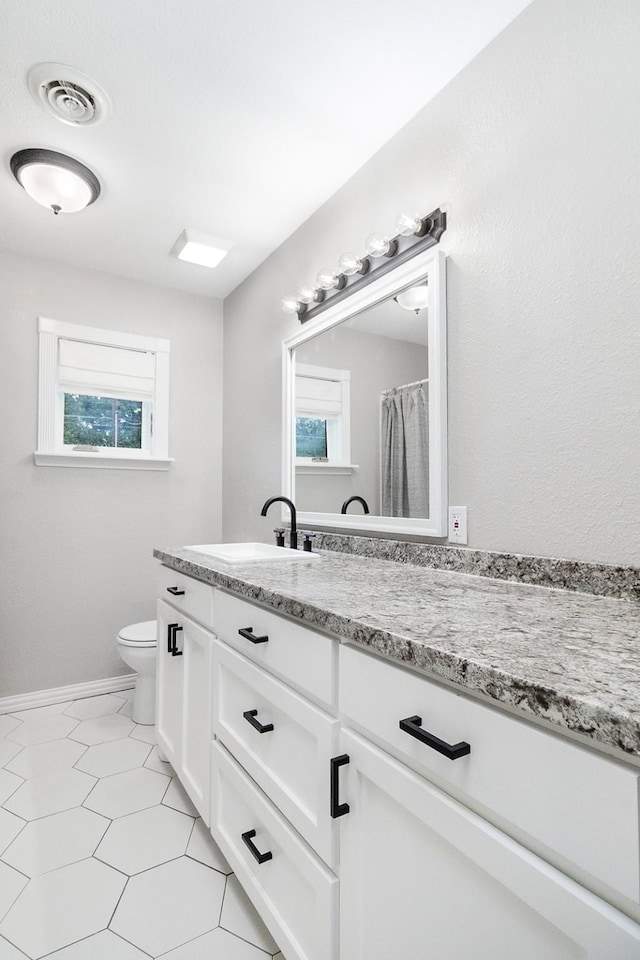 2103 S High St, Brady, TX 76825 - bathroom with toilet, vanity, and baseboards