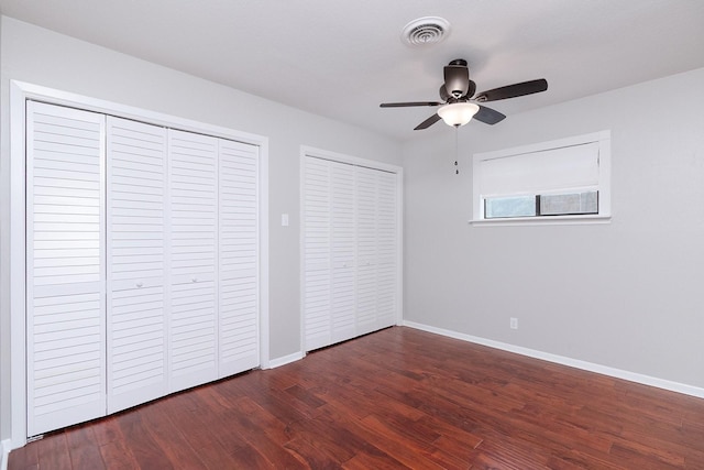 2103 S High St, Brady, TX 76825 - unfurnished bedroom featuring wood finished floors, baseboards, multiple closets, and a ceiling fan