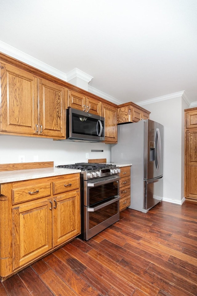 2103 S High St, Brady, TX 76825 - kitchen with appliances with stainless steel finishes, brown cabinets, light countertops, dark wood-type flooring, and crown molding