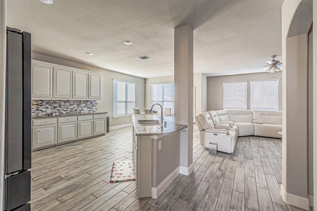 3001 Spring Ct, Midlothian, TX 76065 - kitchen with a sink, freestanding refrigerator, light wood-type flooring, baseboards, and a textured ceiling