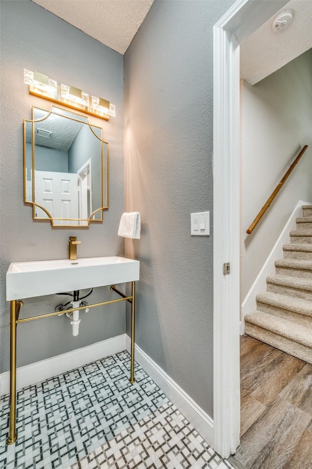 11016 Huntington Rd, Frisco, TX 75035 - bathroom featuring tile patterned floors, baseboards, a textured ceiling, and a sink