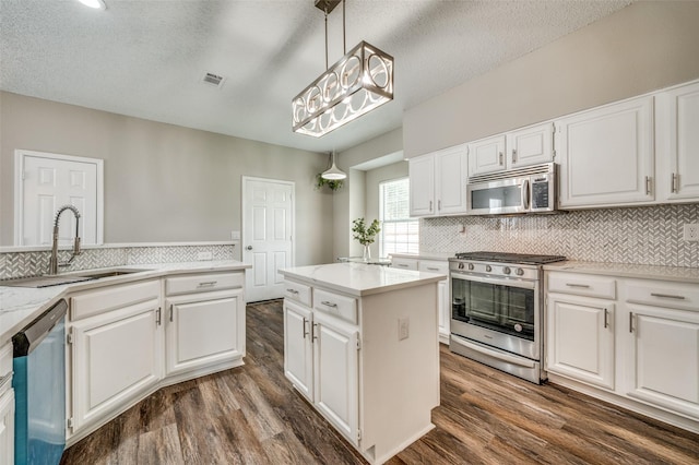 11016 Huntington Rd, Frisco, TX 75035 - kitchen with stainless steel appliances, a sink, dark wood-style floors, decorative backsplash, and a textured ceiling