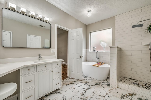 11016 Huntington Rd, Frisco, TX 75035 - bathroom with marble finish floors, a freestanding bath, vanity, a walk in shower, and a textured ceiling
