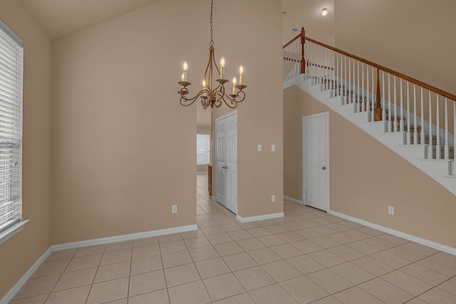 10317 Colfax Dr, Mckinney, TX 75072 - spare room featuring high vaulted ceiling, stairs, a chandelier, light tile patterned floors, and baseboards