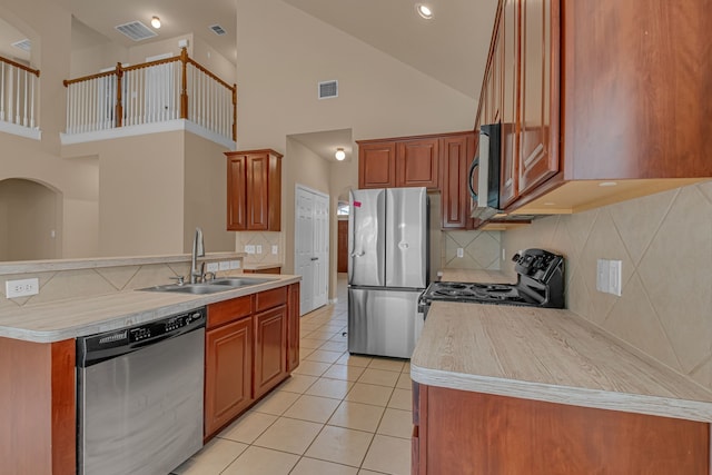 10317 Colfax Dr, Mckinney, TX 75072 - kitchen featuring appliances with stainless steel finishes, a sink, high vaulted ceiling, decorative backsplash, and light tile patterned floors