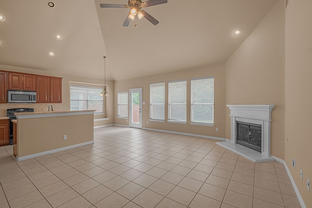 10317 Colfax Dr, Mckinney, TX 75072 - kitchen with stainless steel microwave, range, open floor plan, light countertops, and light tile patterned floors