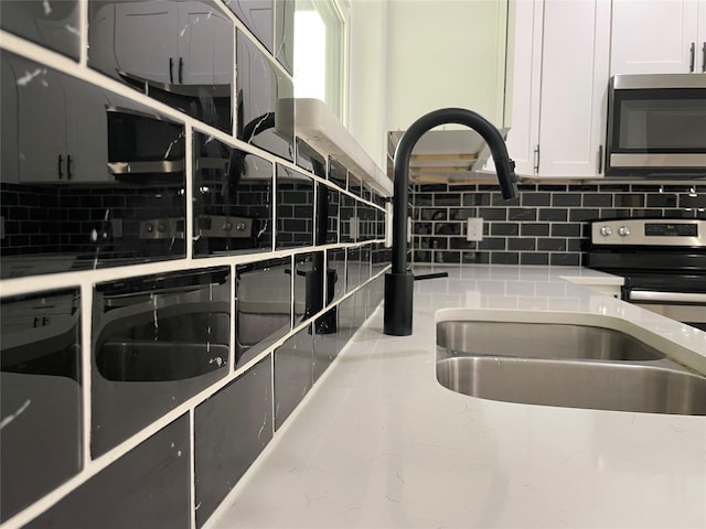 206 E Birch St, Campbell, TX 75422 - kitchen featuring stainless steel appliances, tasteful backsplash, light stone counters, and white cabinets
