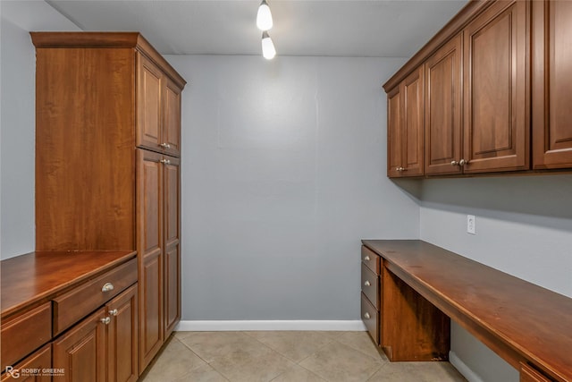 704 Taylor Bend St, Haughton, LA 71037 - clothes washing area with light tile patterned flooring, a desk, and baseboards
