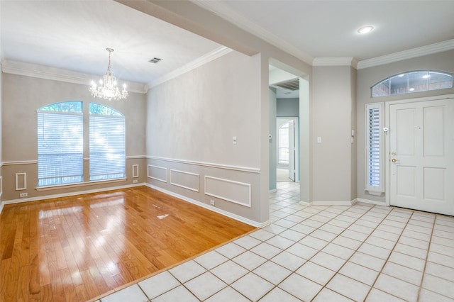3002 Chukar Dr, Mckinney, TX 75072 - entryway with a chandelier, light wood-style flooring, crown molding, baseboards, and wainscoting