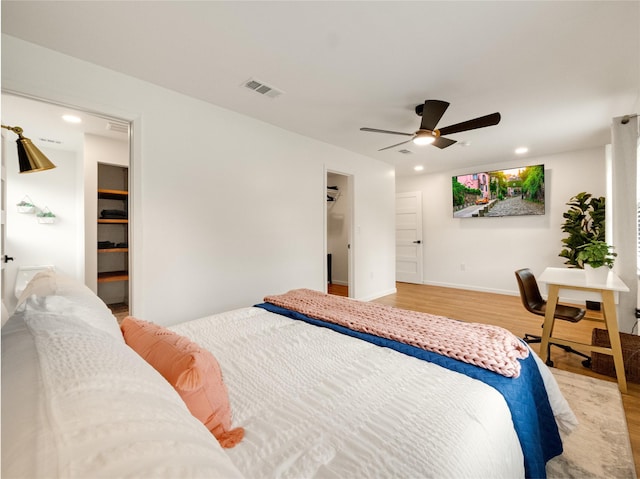 445 Melrose Dr, Richardson, TX 75080 - bedroom with wood finished floors, a ceiling fan, recessed lighting, a walk in closet, and baseboards
