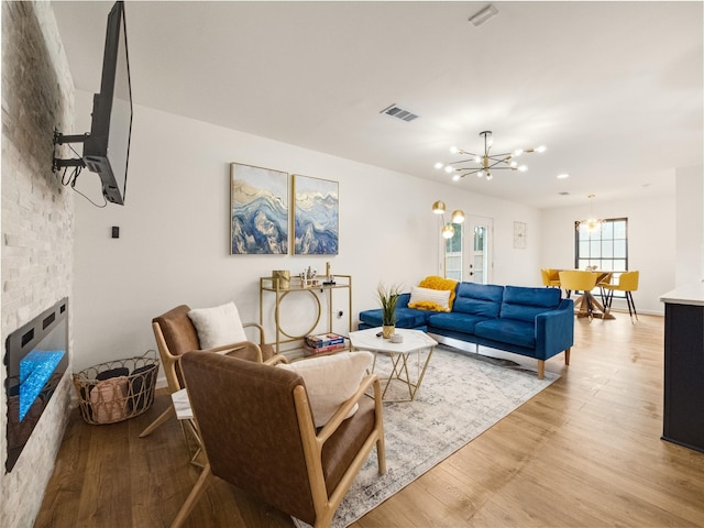 445 Melrose Dr, Richardson, TX 75080 - living area with a chandelier, light wood-style flooring, and a fireplace