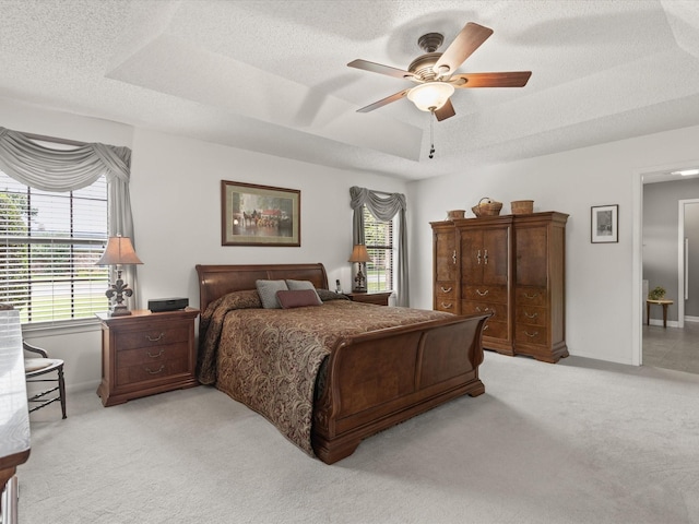 205 Brookview Dr, Decatur, TX 76234 - bedroom with light carpet, a textured ceiling, a raised ceiling, baseboards, and ceiling fan