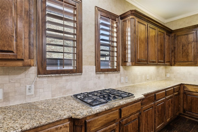 1270 Timber Ln, Frisco, TX 75036 - kitchen with stainless steel gas cooktop, tasteful backsplash, crown molding, and light stone counters
