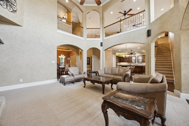 1270 Timber Ln, Frisco, TX 75036 - living room featuring ceiling fan, a chandelier, arched walkways, a high ceiling, and light colored carpet
