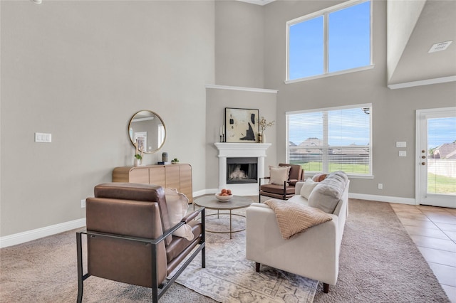 405 Calvert Dr, Midlothian, TX 76065 - living room with baseboards, a towering ceiling, a fireplace with raised hearth, light carpet, and light tile patterned floors