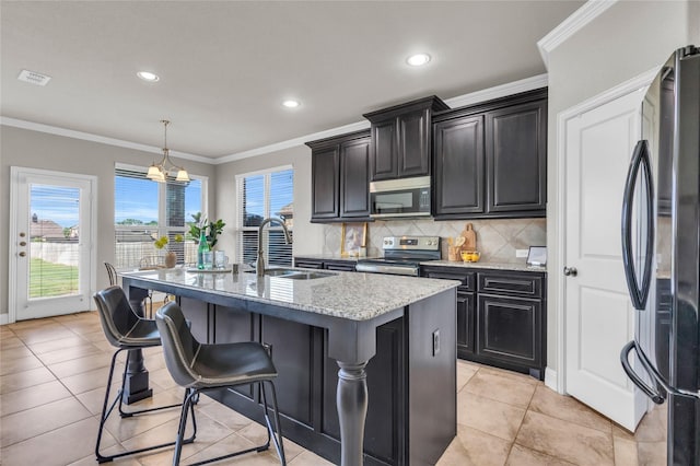 405 Calvert Dr, Midlothian, TX 76065 - kitchen featuring stainless steel electric stove, freestanding refrigerator, a sink, a kitchen island with sink, and a kitchen bar
