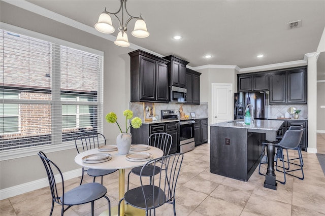405 Calvert Dr, Midlothian, TX 76065 - kitchen with stainless steel appliances, backsplash, a breakfast bar, ornamental molding, and light stone counters