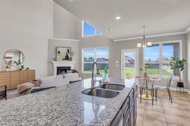 405 Calvert Dr, Midlothian, TX 76065 - kitchen with a sink, light tile patterned floors, a chandelier, a fireplace, and light stone countertops