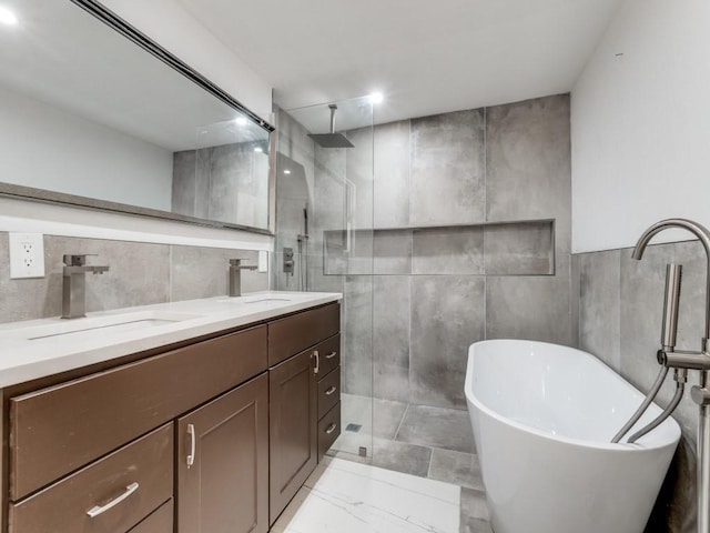809 Cristler Ave, Dallas, TX 75223 - bathroom featuring tile walls, walk in shower, double vanity, a soaking tub, and marble finish floors