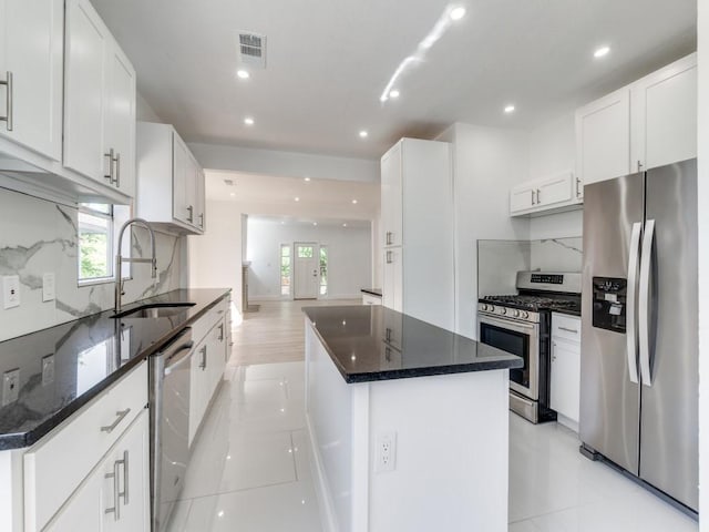 809 Cristler Ave, Dallas, TX 75223 - kitchen featuring stainless steel appliances, a sink, a kitchen island, tasteful backsplash, and recessed lighting