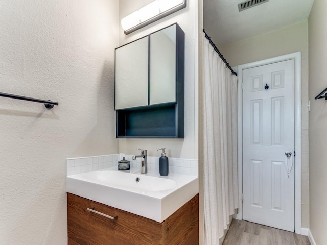 5408 Waltham Ave, Fort Worth, TX 76133 - bathroom featuring vanity, wood finished floors, a textured wall, and a shower with shower curtain
