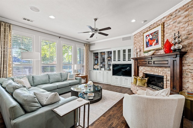 903 Crescent Dr, Highland Village, TX 75077 - living room featuring dark wood-style floors, a ceiling fan, crown molding, plenty of natural light, and a stone fireplace