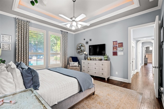 903 Crescent Dr, Highland Village, TX 75077 - bedroom featuring a tray ceiling, arched walkways, crown molding, wood finished floors, and baseboards