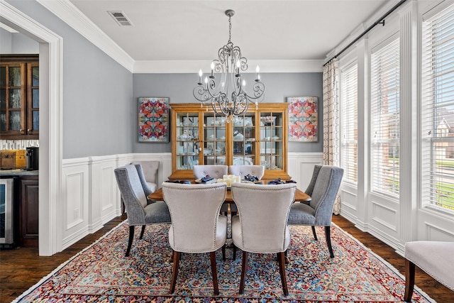 903 Crescent Dr, Highland Village, TX 75077 - dining area featuring plenty of natural light, a chandelier, dark wood-style floors, ornamental molding, and a wainscoted wall