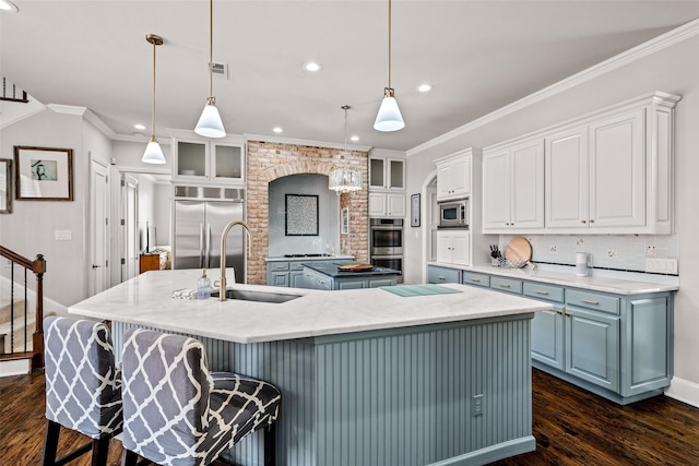 903 Crescent Dr, Highland Village, TX 75077 - kitchen featuring built in appliances, a sink, a large island, dark wood-style flooring, and white cabinets