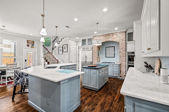 903 Crescent Dr, Highland Village, TX 75077 - kitchen with a large island, a sink, gray cabinetry, ornamental molding, and appliances with stainless steel finishes