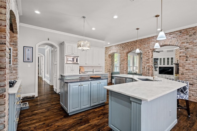 903 Crescent Dr, Highland Village, TX 75077 - kitchen with a sink, a large island, stainless steel appliances, dark wood-style flooring, and arched walkways