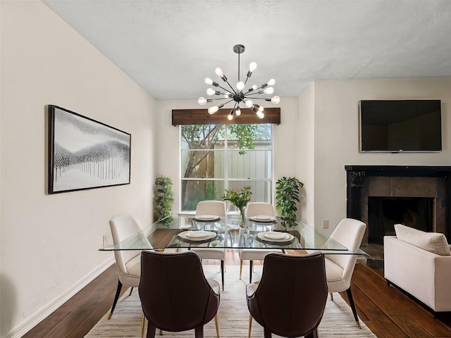 12605 Burninglog Ln, Dallas, TX 75243 - dining space featuring a chandelier, hardwood / wood-style floors, baseboards, and a fireplace