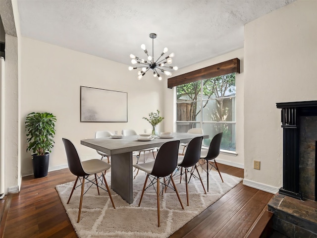 12605 Burninglog Ln, Dallas, TX 75243 - dining space featuring a chandelier, hardwood / wood-style flooring, a glass covered fireplace, and baseboards
