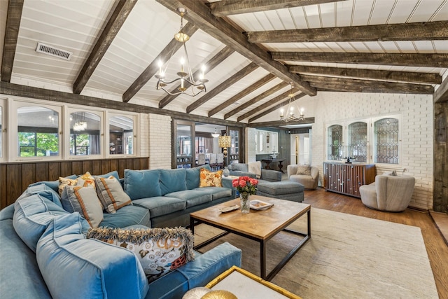4549 Walnut Hill Ln, Dallas, TX 75229 - living room with a chandelier, wood finished floors, and brick wall