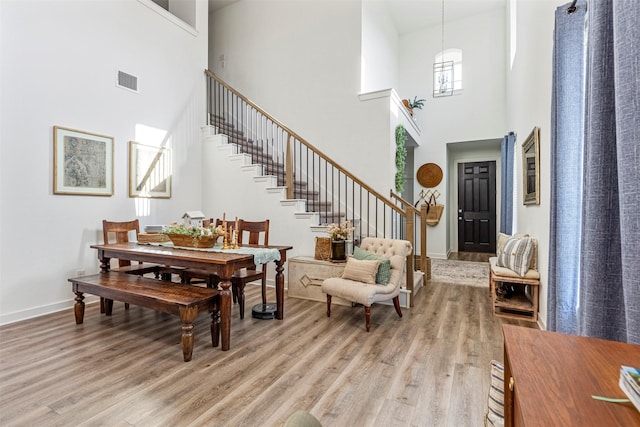 3942 Oak Crk, Denison, TX 75020 - dining room with a high ceiling, light wood finished floors, stairs, and baseboards
