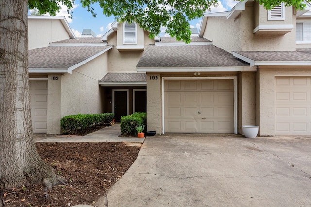 8400 Hickory St Unit 103, Frisco, TX 75034 - view of front of home featuring a shingled roof, concrete driveway, and stucco siding