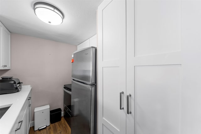 8400 Hickory St Unit 103, Frisco, TX 75034 - kitchen featuring freestanding refrigerator, white cabinets, dark wood finished floors, light countertops, and range with electric cooktop