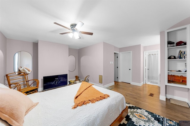 8400 Hickory St Unit 103, Frisco, TX 75034 - bedroom with wood finished floors, baseboards, a ceiling fan, and ensuite bathroom